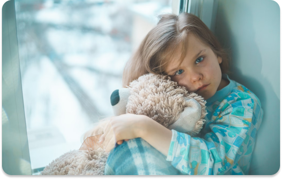 Young girl holds onto her teddy bear
