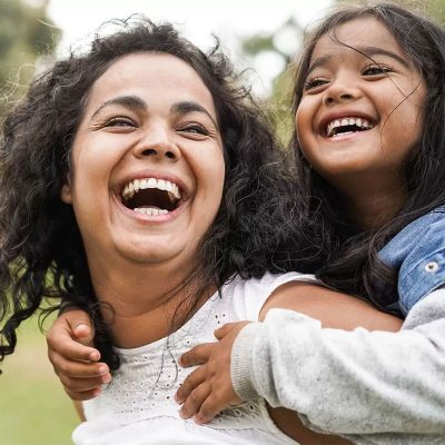 Mother and daughter smiling outside